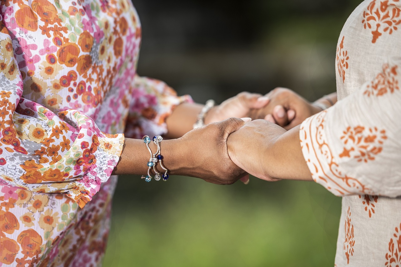 Anziana e adulta che si tengono le mani